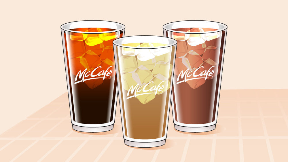 Three McCafé iced coffee drinks in clear cups with ice, showing different shades from dark black to creamy brown.