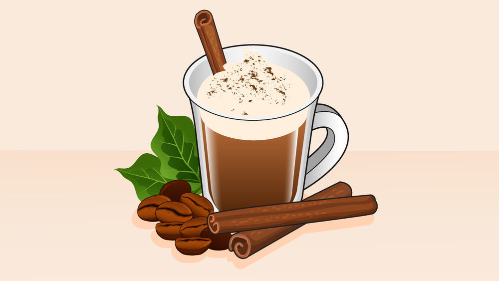 A cinnamon coffee drink in a glass mug, topped with whipped cream and cinnamon, with coffee beans, green leaves, and cinnamon sticks