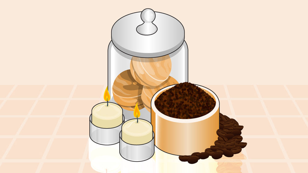 Jar of coffee-scented aroma balls, a bowl of coffee grounds, roasted beans, and two lit candles.
