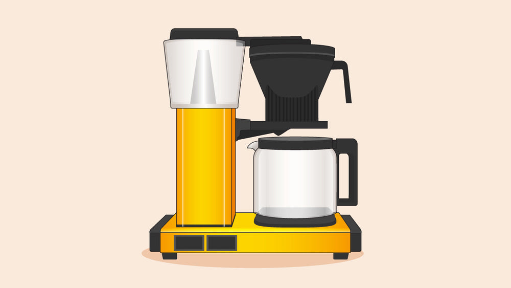 Technivorm Moccamaster coffee maker in yellow with a glass carafe and black filter holder