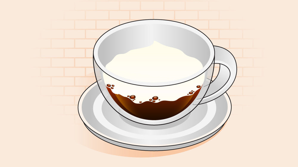 Bone dry cappuccino in a clear cup with espresso and thick milk foam, no steamed milk, on a white saucer.