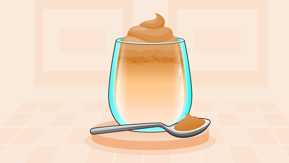 Glass of whipped coffee topped with creamy froth, accompanied by a spoonful of the coffee mixture