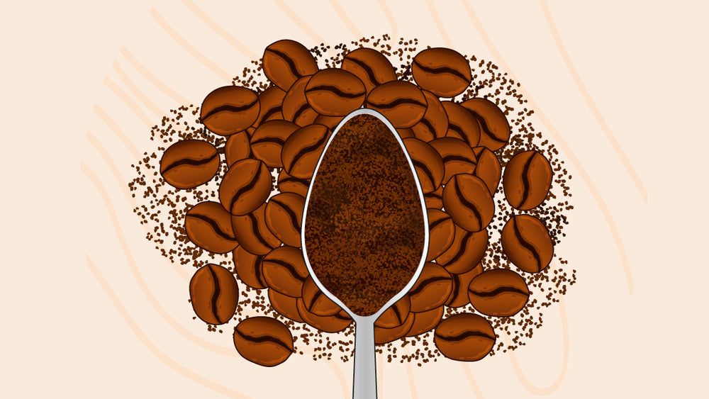 Spoon filled with ground coffee placed on top of whole roasted coffee beans with scattered coffee grounds