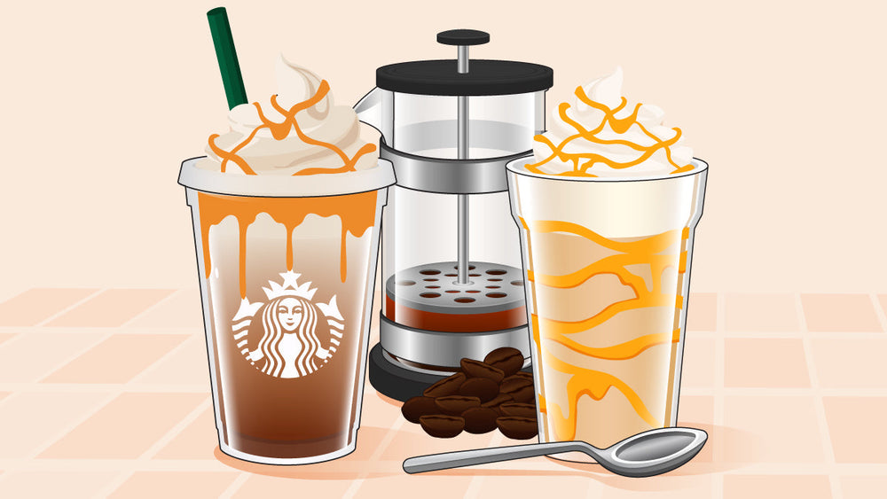 wo caramel-drizzled frappuccinos beside a French press, coffee beans, and a spoon.