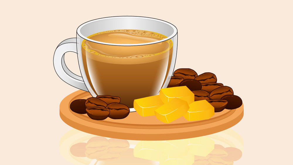 Glass mug of keto coffee on a wooden tray with coffee beans and yellow butter cubes.