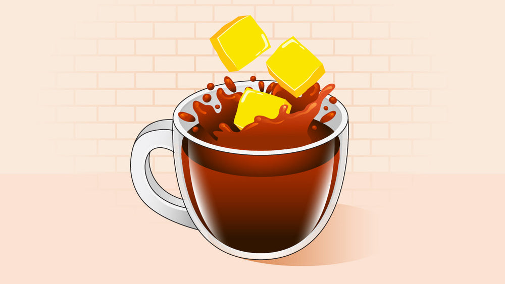 Transparent mug of coffee with three yellow butter cubes splashing into it.